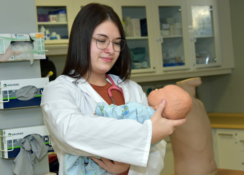 Étudiante tenant un bébé mannequin